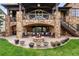 Multi-level outdoor living space with stone accents, a fire pit, and comfortable seating at 7188 Raphael Ln, Littleton, CO 80125