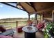 Inviting covered patio featuring comfortable seating, an outdoor fireplace, and scenic views of the surrounding landscape at 7188 Raphael Ln, Littleton, CO 80125