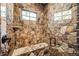 Unique shower featuring stone walls and a built-in bench at 7188 Raphael Ln, Littleton, CO 80125