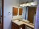Bathroom featuring a vanity, sink, mirror, and wooden cabinets at 11375 W Maplewood Ave, Littleton, CO 80127