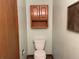 Small bathroom with oak cabinets and small storage shelf above the commode at 11375 W Maplewood Ave, Littleton, CO 80127