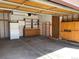 Spacious garage with an automatic door opener, built-in storage shelves, cabinets, and a refrigerator at 11375 W Maplewood Ave, Littleton, CO 80127