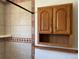 Shower with tile surround and wooden cabinet at 11375 W Maplewood Ave, Littleton, CO 80127