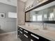 Modern bathroom with a double vanity, sleek black cabinets, and a large mirror with stylish lighting at 2508 S Pennsylvania St, Denver, CO 80210