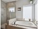 Luxurious bathroom featuring a soaking tub, separate shower, and bright natural light from a window at 2508 S Pennsylvania St, Denver, CO 80210