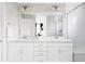 Bright bathroom featuring a double vanity with white cabinets, a large mirror, and a glass-enclosed shower at 8917 Yates Dr, Westminster, CO 80031
