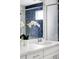 Close up on a bathroom vanity featuring a white countertop, single sink, and elegant orchid decoration at 8917 Yates Dr, Westminster, CO 80031