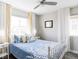 Bright bedroom featuring a decorative wrought iron bed frame, ceiling fan, and white window curtains at 8917 Yates Dr, Westminster, CO 80031