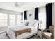 Bright bedroom features a king bed, bedside tables, and windows with sheer and dark blue curtains at 8917 Yates Dr, Westminster, CO 80031