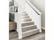 Carpeted staircase with white railings, showcasing a clean design and leading to the upper level of the home at 8917 Yates Dr, Westminster, CO 80031