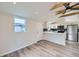Modern kitchen with stainless steel appliances, white cabinetry, and stylish backsplash, complemented by wood-look floors at 3379 S Eliot St, Englewood, CO 80110