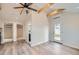 Open-concept living space with vaulted ceilings, exposed beams, modern ceiling fan, luxury vinyl plank flooring, and mini-split at 3379 S Eliot St, Englewood, CO 80110