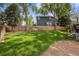 The backyard features a lush green lawn with mature trees and a privacy fence at 9478 Burgundy Cir, Highlands Ranch, CO 80126