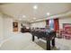 Finished basement with a foosball table, a built-in wet bar, and seating area for entertaining at 9478 Burgundy Cir, Highlands Ranch, CO 80126