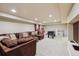Open basement layout featuring a sectional sofa, foosball table, and play area, ideal for Gathering entertainment at 9478 Burgundy Cir, Highlands Ranch, CO 80126