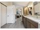 Bathroom with a dual sink vanity, tiled floor, and a view into the bedroom; neutral paint throughout at 9478 Burgundy Cir, Highlands Ranch, CO 80126