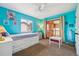Bedroom with bright turquoise walls, a ceiling fan, and balcony access, perfect for relaxation and outdoor enjoyment at 9478 Burgundy Cir, Highlands Ranch, CO 80126