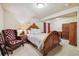 Bedroom featuring a large wooden bed, red armchair, and accent wall, creating a cozy retreat at 9478 Burgundy Cir, Highlands Ranch, CO 80126