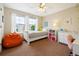 Bright bedroom with a single bed, a large window, and a cozy orange beanbag chair at 9478 Burgundy Cir, Highlands Ranch, CO 80126