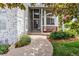 Inviting front porch with walkway, white stone accents, comfortable seating, and lush landscaping at 9478 Burgundy Cir, Highlands Ranch, CO 80126
