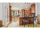 An eat-in kitchen shows wooden cabinetry, stainless appliances, a breakfast nook and wood floors at 9478 Burgundy Cir, Highlands Ranch, CO 80126