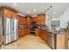 This kitchen features stainless steel appliances, wooden cabinets, and a stone countertop island at 9478 Burgundy Cir, Highlands Ranch, CO 80126