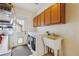 This laundry room offers plenty of storage with upper cabinets, utility sink, and modern washer and dryer at 9478 Burgundy Cir, Highlands Ranch, CO 80126