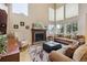 Spacious living room featuring tall windows for natural light, a cozy fireplace, and comfortable seating at 9478 Burgundy Cir, Highlands Ranch, CO 80126