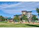 Bright community playground with green lawn, play structure and apartment homes on a bright, sunny day at 9478 Burgundy Cir, Highlands Ranch, CO 80126