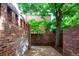 Private backyard with brick walls, mature trees, and serene setting for outdoor relaxation at 2409 E Cedar Ave, Denver, CO 80209