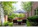 Charming backyard garden with patio seating, shady umbrella, and brickwork details at 2409 E Cedar Ave, Denver, CO 80209