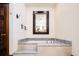 Elegant bathroom with a soaking tub, marble steps, and a dark wood door, accented by decorative hooks at 2409 E Cedar Ave, Denver, CO 80209