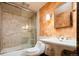 Bathroom offers a mosaic tile shower, stone walls, and a designer sink with a pedestal base at 2409 E Cedar Ave, Denver, CO 80209