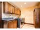 Laundry room features a utility sink, granite countertops, custom cabinets, and stainless steel washer/dryer at 2409 E Cedar Ave, Denver, CO 80209
