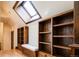 Loft space with built-in bookshelves, a window seat, a skylight, and hardwood flooring at 2409 E Cedar Ave, Denver, CO 80209
