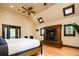 Spacious bedroom featuring a fireplace, wood floors, a ceiling fan, and ample natural light at 2409 E Cedar Ave, Denver, CO 80209