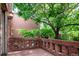 Inviting patio with brick railing, lush trees, and traditional brickwork in a serene outdoor setting at 2409 E Cedar Ave, Denver, CO 80209
