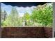 Scenic view from a window overlooking lush greenery and mature trees, framed by a brick facade at 2409 E Cedar Ave, Denver, CO 80209