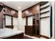 Closet featuring custom dark wood cabinets, drawers, shelving, and glass-front cabinets for elegant storage at 2409 E Cedar Ave, Denver, CO 80209