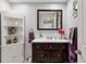 Charming powder room with wainscoting, decorative mirror, and dark wood vanity at 16200 Quarry Hill Dr, Parker, CO 80134