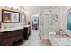 Bathroom featuring dual sinks, a walk-in shower, and a separate soaking tub at 16200 Quarry Hill Dr, Parker, CO 80134