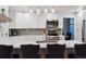 Open kitchen with white cabinets, quartz countertops, stainless appliances, and decorative lighting at 16200 Quarry Hill Dr, Parker, CO 80134