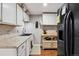 Efficient kitchen with white cabinetry, black appliances, and a vintage chalkboard, providing a functional space at 16200 Quarry Hill Dr, Parker, CO 80134
