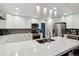 Open kitchen with white cabinets, quartz countertops, stainless appliances, and a double sink at 16200 Quarry Hill Dr, Parker, CO 80134