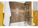 Close up on a shower-tub with brown tiled walls and glass door, with a white towel hanging beside it at 416 W 3Rd Ave, Denver, CO 80223