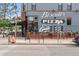 Biscuits Pizza & Beer entices with a gray painted brick exterior, signage, and outdoor flower box seating area at 416 W 3Rd Ave, Denver, CO 80223