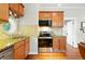 Well-lit kitchen featuring wood cabinetry, stainless steel appliances, granite countertops and mosaic tile backsplash at 416 W 3Rd Ave, Denver, CO 80223