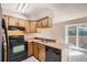 Kitchen with wood cabinets, black appliances, and sliding door at 1342 S Idalia St, Aurora, CO 80017