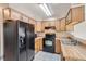 Kitchen boasts wood cabinets and black appliances at 1342 S Idalia St, Aurora, CO 80017