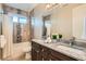Modern bathroom features dual sinks, granite countertops, decorative tile accents, and a shower-tub combination at 1916 S Elati St, Denver, CO 80223